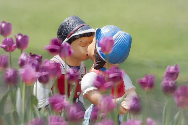 两个接吻娃娃在郁金香花园. — 图库照片
