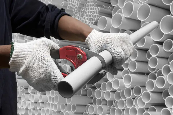 Worker cutting pvc pipe in construction site — Stock Photo, Image