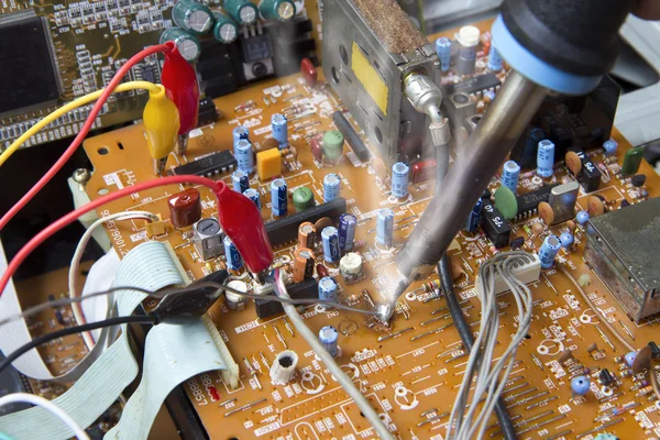 Soldering iron working on electronic boards — Stock Photo, Image