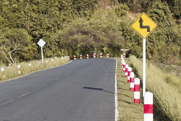 Verkehrsschild warnt vor scharfer Kurve auf schmaler Straße — Stockfoto