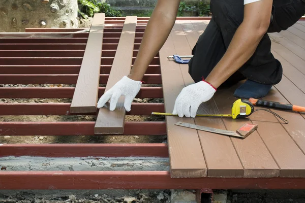 Trabajador instalando suelo de madera para patio — Foto de Stock