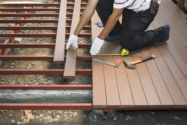 Arbeiter verlegt Holzboden für Terrasse — Stockfoto