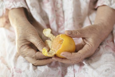 yaşlı kadının el Çinli bir portakal soyma