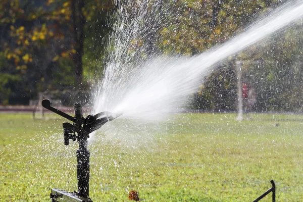 Sprinkler huvud vattna gräset i sport fältet. — Stockfoto