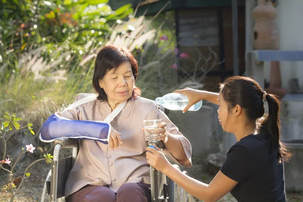 Unga asiatiska hand tar senior kvinnan — Stockfoto