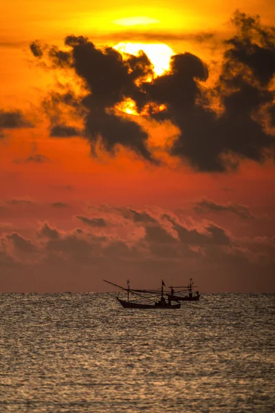 Рыбак на лодке на драматическом восходе солнца — стоковое фото