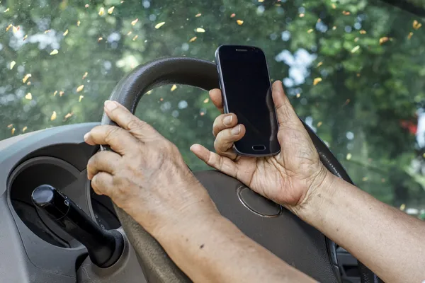 Femme âgée conduisant une voiture et appelant avec un téléphone mobile — Photo