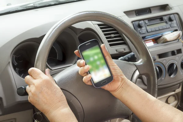 Donna anziana guida auto e chiamando con il telefono cellulare — Foto Stock