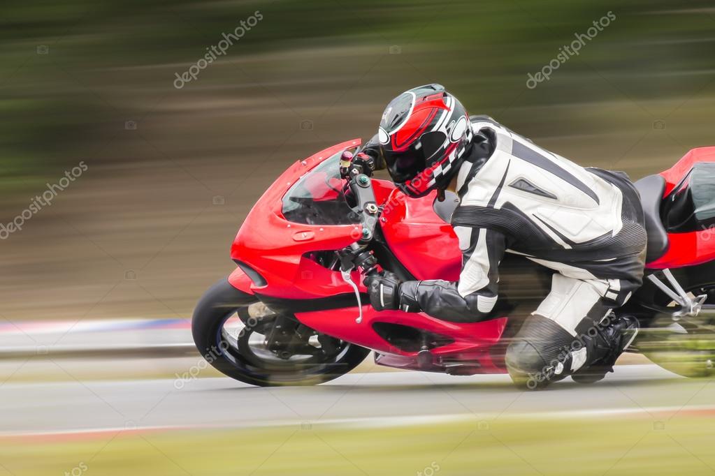 Racing bike rider leaning into a fast corner on track Stock Photo