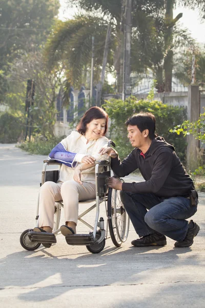 Aziatisch mens nemen zijn bejaarde moeder voor een wandeling in de ochtend — Stockfoto