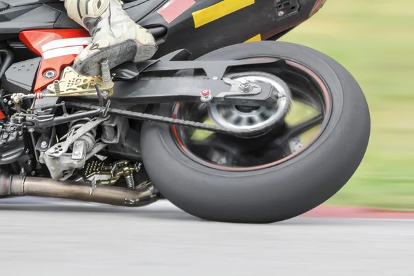 Racing bike rider leaning into a fast corner on track — Stock Photo, Image