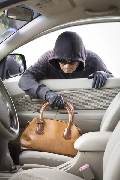 Thief stealing handbag from car — Stock Photo, Image