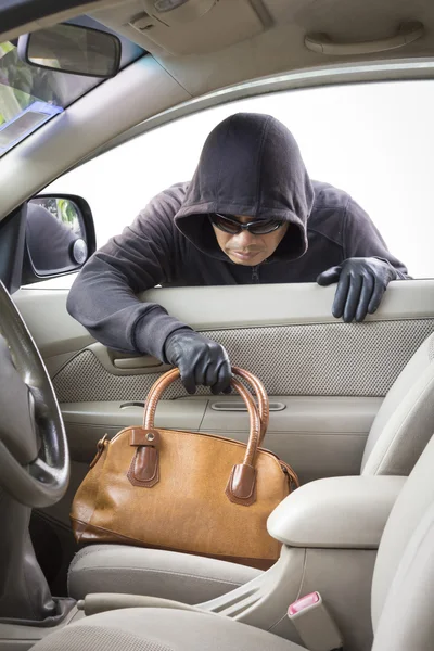 Thief stealing handbag from car Royalty Free Stock Photos