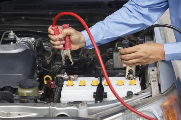 Zakenman jumper kabels gebruiken om te beginnen met een auto in de parking op te rijden — Stockfoto