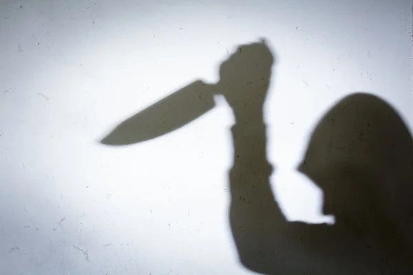 Mão Masculina Sombra com Faca de Cozinha, na parede de concreto — Fotografia de Stock
