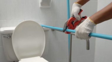 İşçi eski banyonun duvarına yüzen boru hattı kuruyor.
