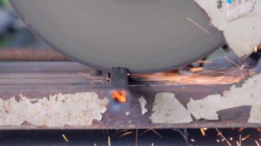 İşçi eski dairesel testereyle metal bir boru kesiyor. 