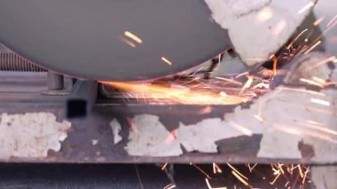 İşçi eski dairesel testereyle metal bir boru kesiyor. 