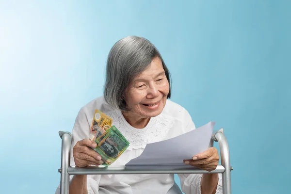 Elderly Asian Woman Smile While Reading Letter Hold Australian Banknote — Stockfoto