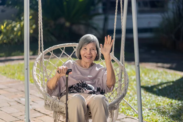 Glimlachen Bejaarde Aziatische Vrouw Zwaaien Naar Camera Swing — Stockfoto