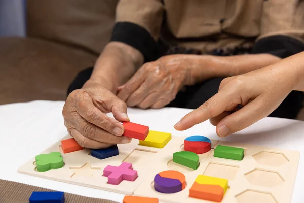 Caregiver Senior Woman Playing Wooden Shape Puzzles Game Dementia Prevention — Stock Photo, Image