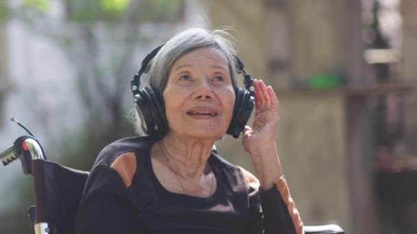 Asiatique Senior Femme Écoute Musique Avec Casque Dans Cour Arrière — Video