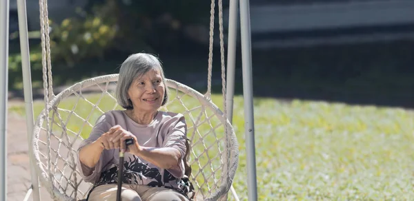 年长的亚洲女人在后院荡秋千放松 — 图库照片