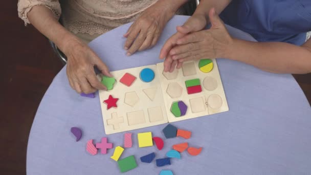 Cuidador Mujer Mayor Jugando Rompecabezas Madera Juego Para Prevención Demencia — Vídeo de stock