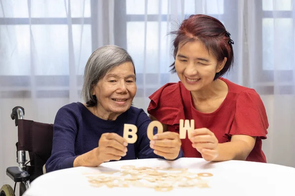高齢女性は娘と精神的な健康と記憶を向上させるためのアルファベットゲームをプレイ — ストック写真