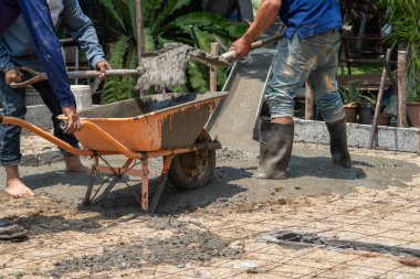 Unsafe construction of Myanmar migrant workers while pouring concrete slab in construction site , Thailand.