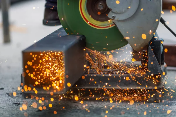 Takım yıldız bölgesinde çelik kare boru kesen işçiler.