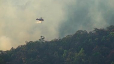 Yangın söndürme helikopteri yangına su bırakıyor.