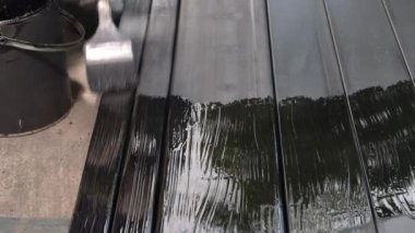 İnşaat alanında çeliği boyayan bir işçi..