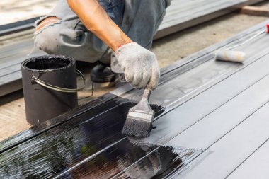 İnşaat alanında çeliği boyayan bir işçi..