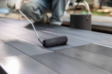 İnşaat alanında çeliği boyayan bir işçi..