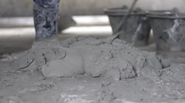 İnşaat alanında duvarı alçılamak için havan harcı karıştıran bir işçi.