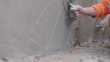 İnşaat işçisi duvar yüzeyini sıva yapıyor..