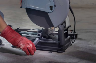 İnşaat alanında çelik dikdörtgen boru kesen işçiler.