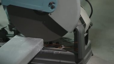 İnşaat alanında çelik dikdörtgen boru kesen işçiler.