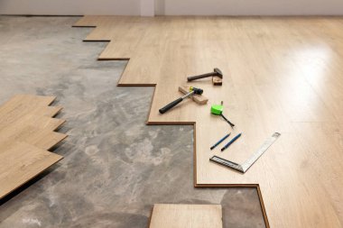 Worker Installing Interlocking laminate floor, home renovation.