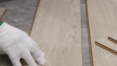 Worker Installing Interlocking laminate floor, home renovation.