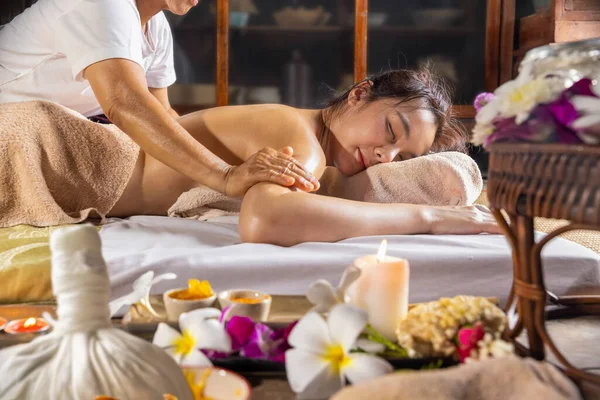 Woman relaxing while get oil massage at thai traditional spa salon.