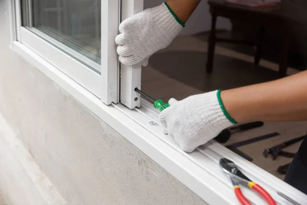 Construction worker repairing the sliding window.