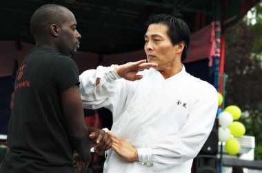 Unidentified participants show martial arts during Asia & U festival clipart