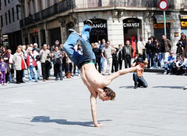 Unidentified urban street dancer demonstrates his art to tourists