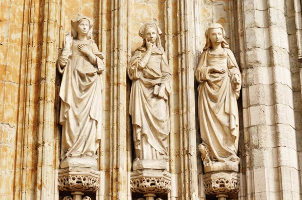 Três estátuas medievais de mulheres à entrada na igreja católica Petit Sablon em Bruxelas — Fotografia de Stock