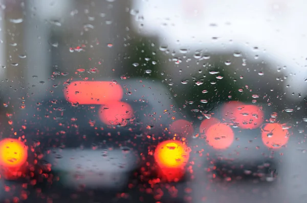 Yağmur damlaları araba penceresi ve ışıklar