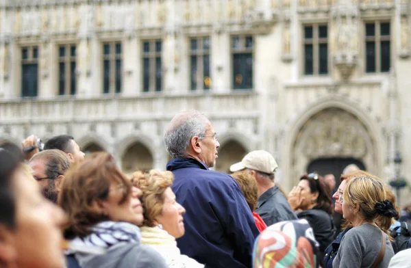 Turyści zagraniczni słuchać przewodnika na zatłoczone w sezonie grand miejsce na 16 czerwca 2012 r. w Brukseli — Zdjęcie stockowe