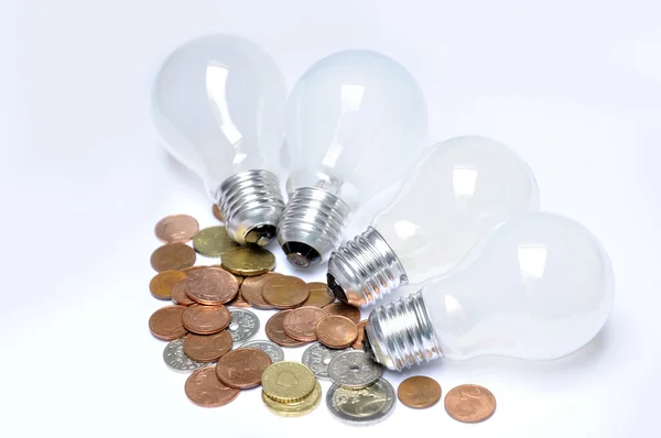 Lampade e monete incandescenti come concetto di economia energetica — Foto Stock