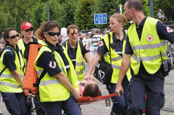 La squadra della Croce Rossa belga aiuta a persona con colpo di sole durante la Giornata Nazionale del Belgio — Foto Stock